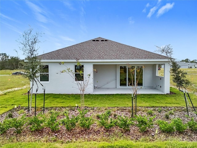 back of property with a patio area and a yard