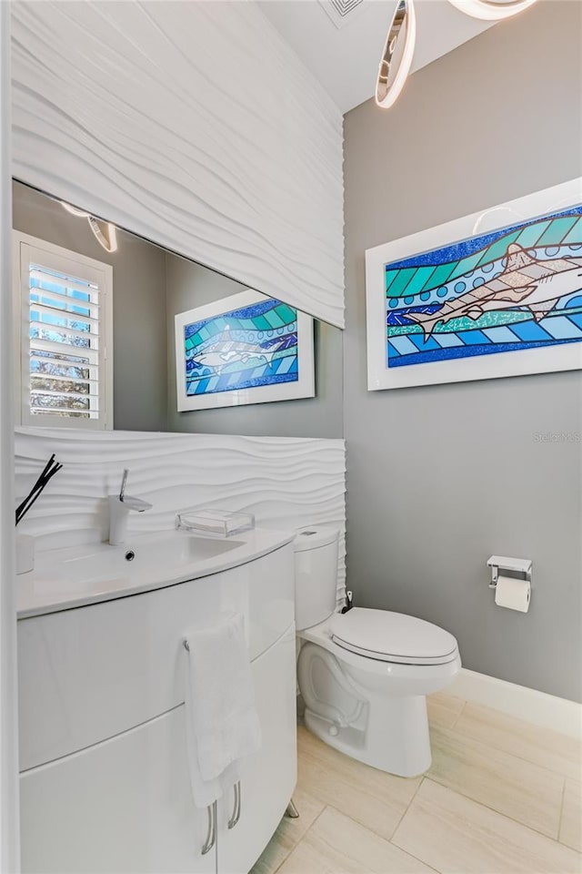 bathroom with toilet, tile patterned flooring, and sink