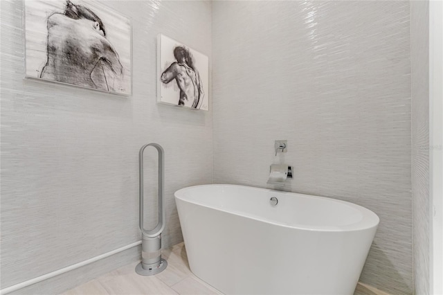 bathroom with a washtub and tile patterned floors