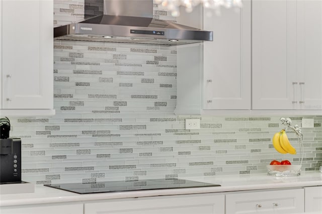 kitchen with white cabinetry, wall chimney range hood, backsplash, and black electric cooktop