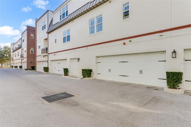 view of property with a garage and a wall mounted air conditioner