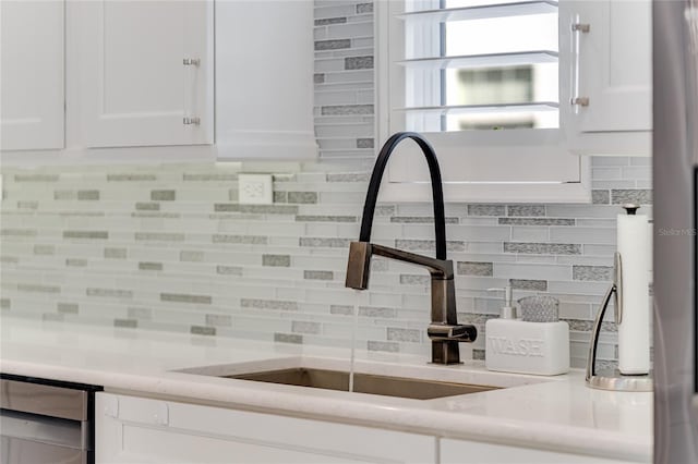 kitchen featuring white cabinetry, sink, and backsplash