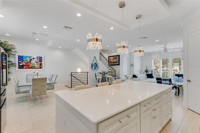 kitchen featuring hanging light fixtures, a center island, white cabinets, and an inviting chandelier