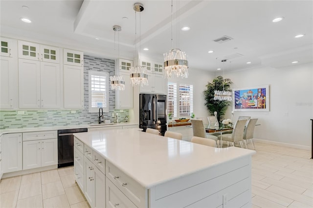 kitchen with sink, white cabinetry, stainless steel appliances, a center island, and decorative light fixtures