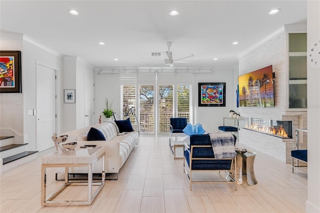 living room featuring a fireplace, ornamental molding, and ceiling fan