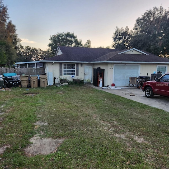 ranch-style house featuring a lawn and a garage