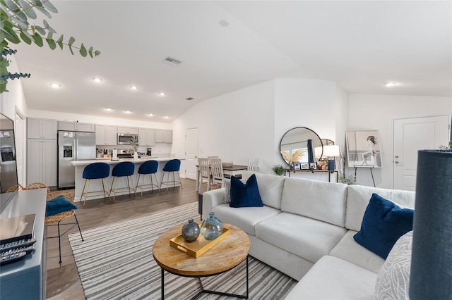 living room featuring lofted ceiling and hardwood / wood-style floors