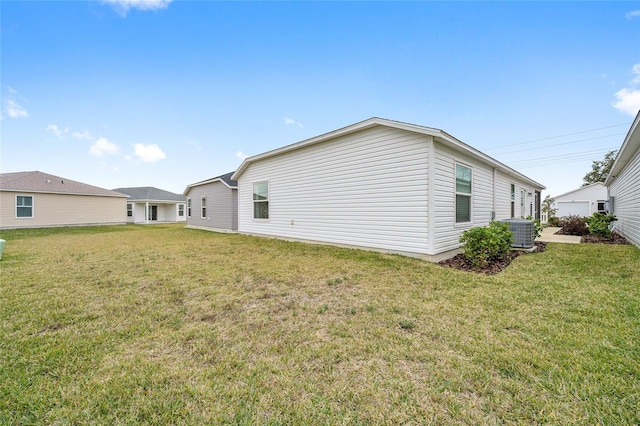 rear view of property featuring a lawn and central AC