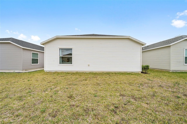 rear view of property featuring a yard