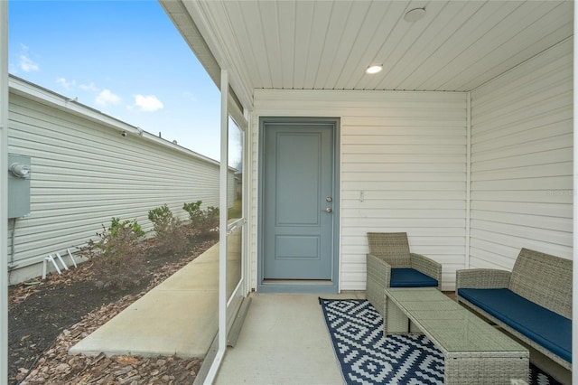 view of exterior entry with outdoor lounge area and a patio area