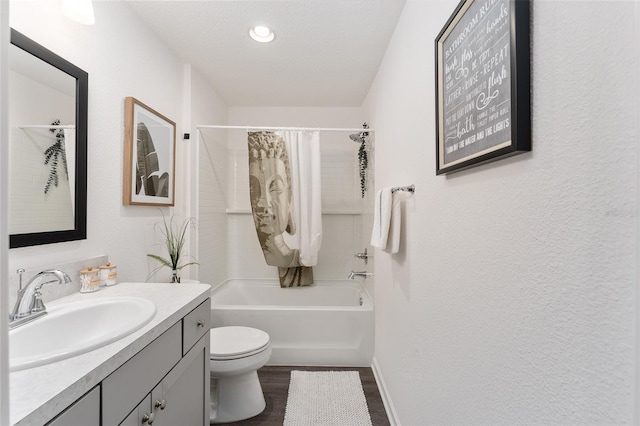 full bathroom with a textured ceiling, toilet, wood-type flooring, shower / bath combo with shower curtain, and vanity