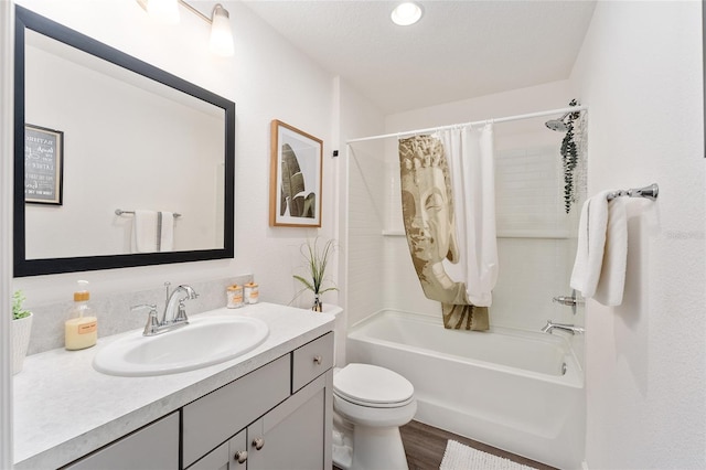 full bathroom with a textured ceiling, shower / bathtub combination with curtain, toilet, wood-type flooring, and vanity