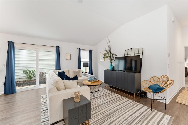 living room featuring vaulted ceiling and hardwood / wood-style flooring