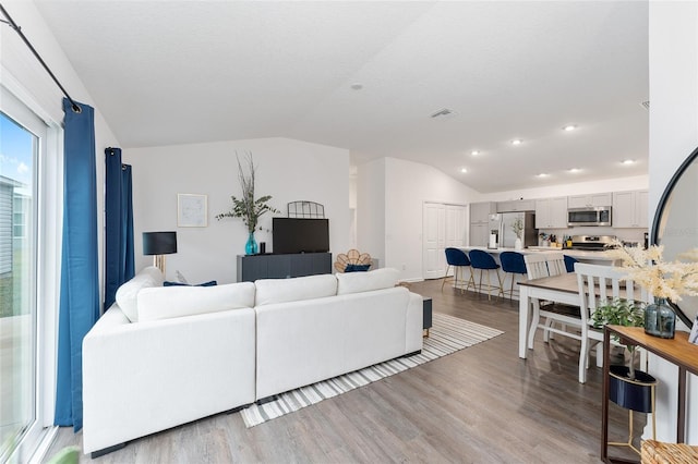 living room with lofted ceiling and light wood-type flooring