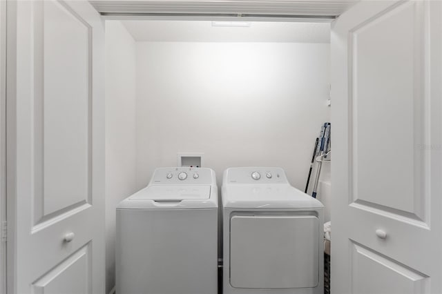 clothes washing area with washing machine and clothes dryer