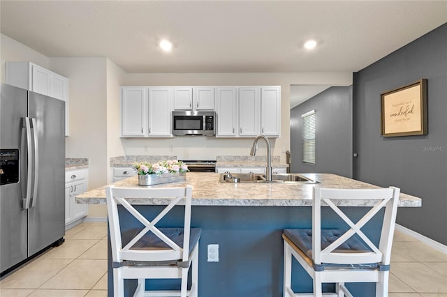 kitchen with a kitchen breakfast bar, an island with sink, stainless steel appliances, and sink