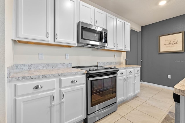 kitchen with white cabinets, light tile patterned flooring, and appliances with stainless steel finishes