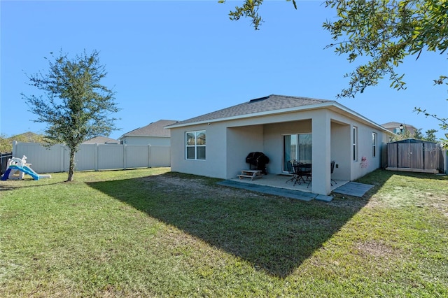 rear view of property with a yard and a patio area