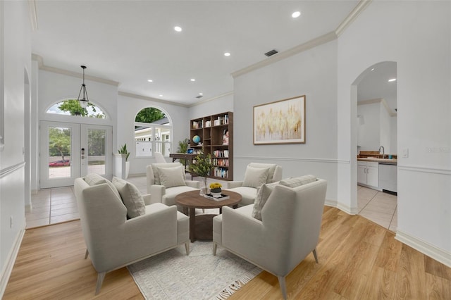 11941 Graces Way, Clermont, FL 34711 - living area featuring crown molding, recessed lighting, arched walkways, light wood finished floors, and french doors