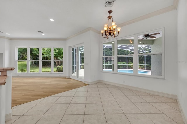 11941 Graces Way, Clermont, FL 34711 - unfurnished dining area featuring healthy amount of natural light, ornamental molding, tile patterned floors, a chandelier, and a ceiling fan