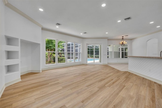 11941 Graces Way, Clermont, FL 34711 - unfurnished living room featuring crown molding, a chandelier, light wood-style floors, recessed lighting, and built in shelves