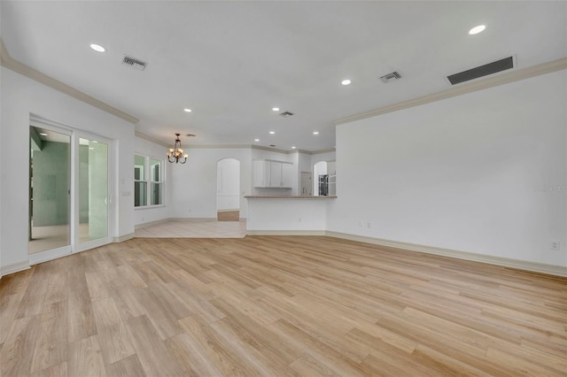 11941 Graces Way, Clermont, FL 34711 - unfurnished living room featuring a chandelier, crown molding, light wood-type flooring, recessed lighting, and arched walkways