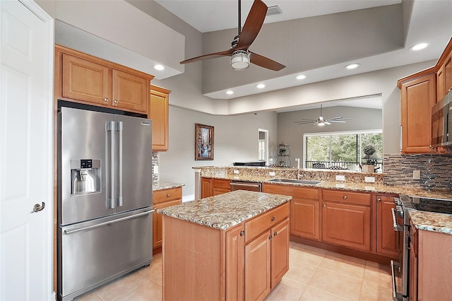 kitchen featuring kitchen peninsula, a center island, backsplash, appliances with stainless steel finishes, and sink