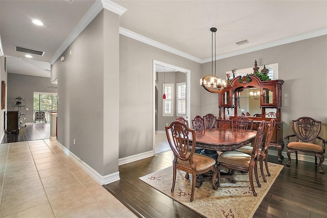 dining area featuring hardwood / wood-style flooring, an inviting chandelier, and crown molding