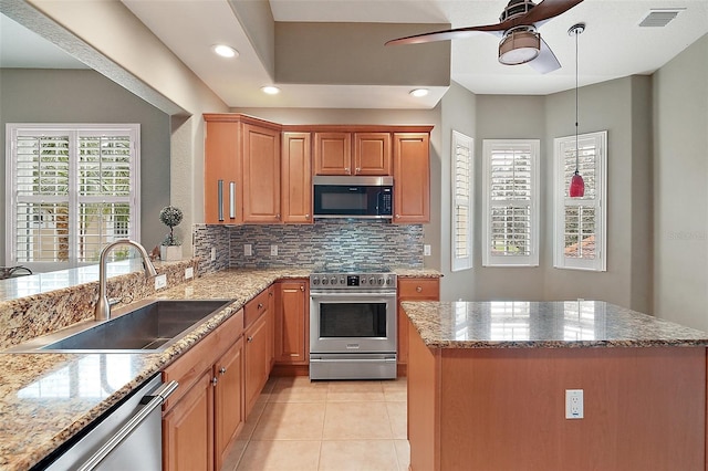 kitchen with light tile patterned floors, tasteful backsplash, appliances with stainless steel finishes, ceiling fan, and sink