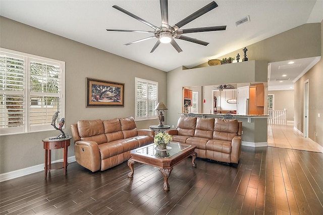 living room with ceiling fan, dark hardwood / wood-style flooring, and vaulted ceiling