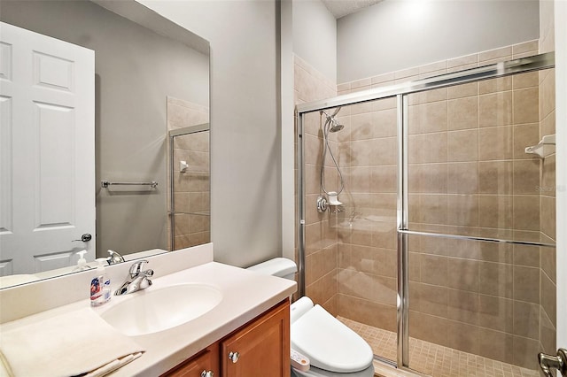 bathroom featuring walk in shower, vanity, and toilet