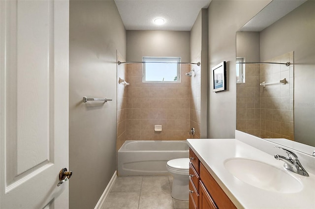 full bathroom featuring tile patterned flooring, toilet, vanity, tiled shower / bath, and a textured ceiling