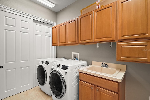 laundry area featuring sink, cabinets, washing machine and dryer, and light tile patterned flooring