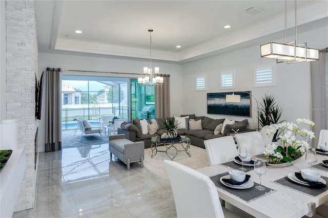 dining room featuring a chandelier and a raised ceiling