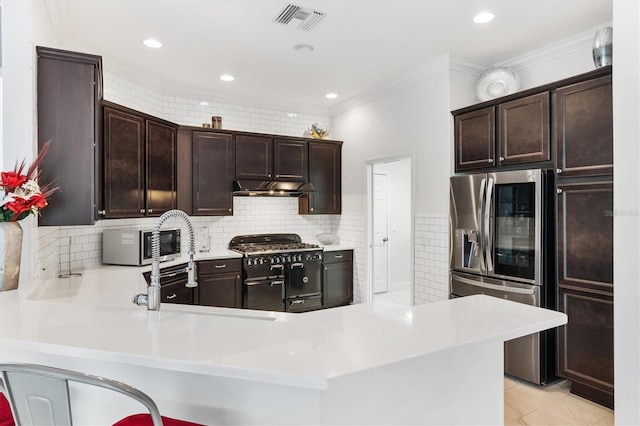 kitchen with kitchen peninsula, dark brown cabinets, and stainless steel appliances