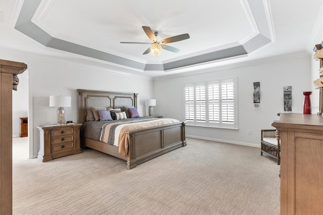 bedroom featuring a tray ceiling, ceiling fan, crown molding, and light colored carpet