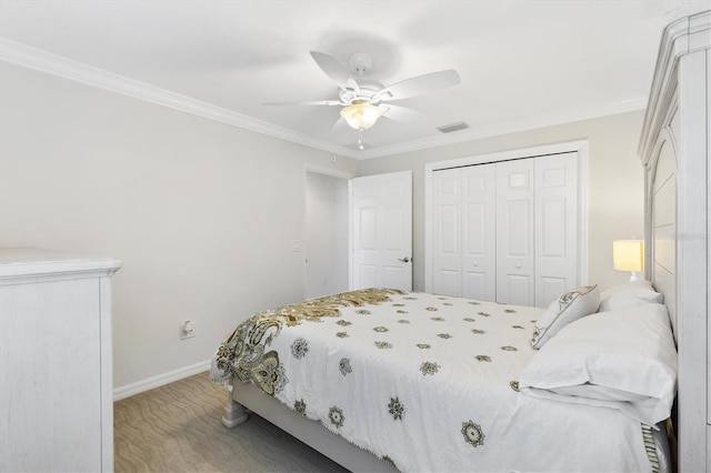 bedroom with carpet flooring, ceiling fan, ornamental molding, and a closet