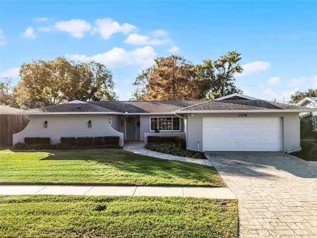 ranch-style home with a garage and a front lawn