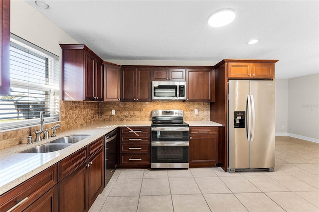 kitchen with decorative backsplash, sink, light tile patterned floors, and appliances with stainless steel finishes