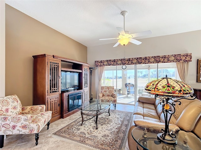 tiled living room with ceiling fan, vaulted ceiling, and a healthy amount of sunlight