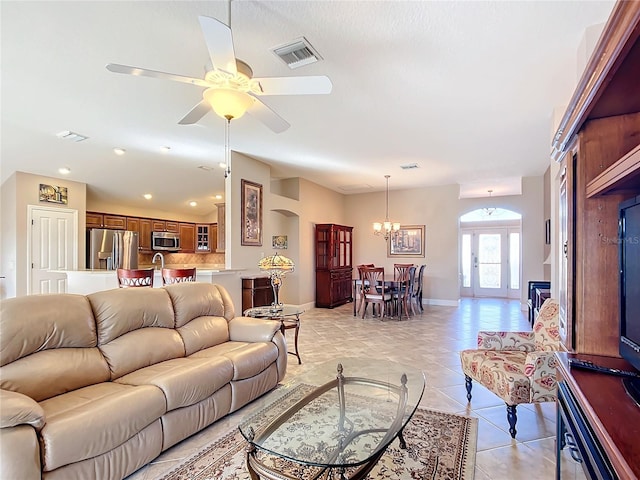 living room featuring french doors, ceiling fan with notable chandelier, and light tile patterned floors