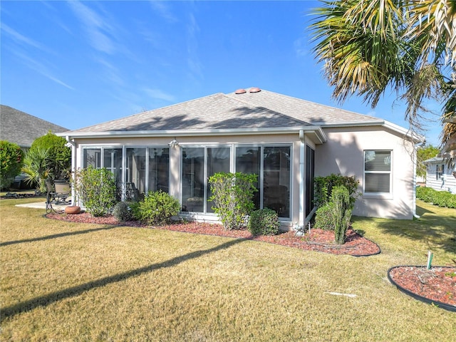 back of property with a sunroom and a lawn