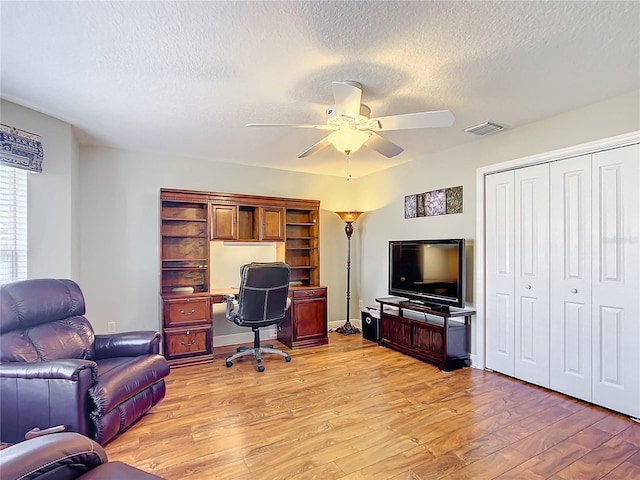 office space with ceiling fan, light hardwood / wood-style floors, and a textured ceiling