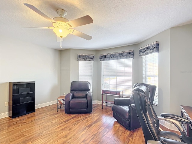 office space with ceiling fan, wood-type flooring, and a textured ceiling
