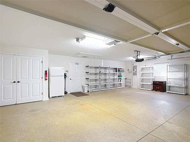 garage with a garage door opener, white fridge, and electric panel