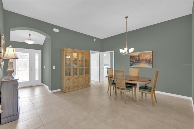 dining room featuring light tile patterned floors, vaulted ceiling, and an inviting chandelier