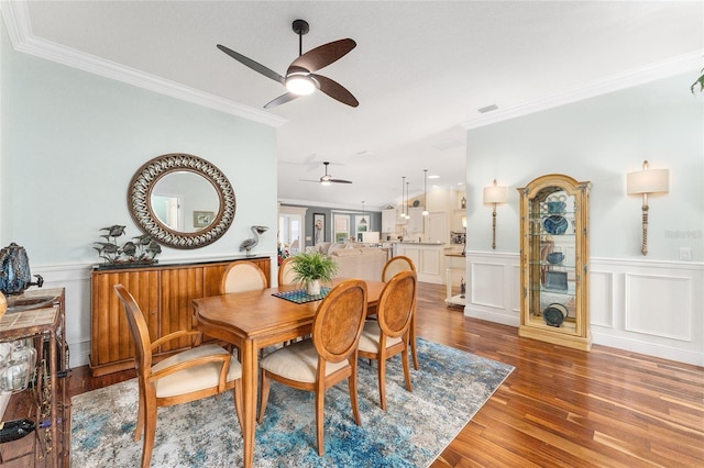 dining space featuring crown molding, ceiling fan, and dark wood-type flooring