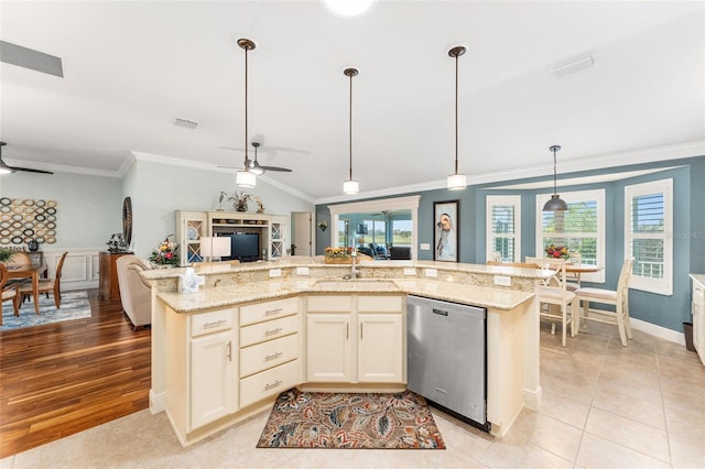 kitchen with ceiling fan, sink, stainless steel dishwasher, pendant lighting, and a center island with sink