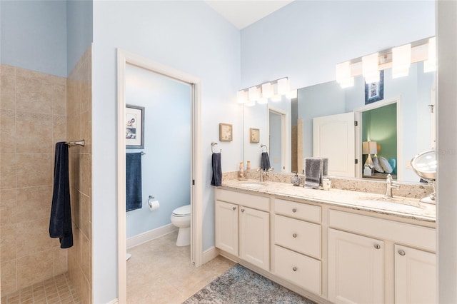 bathroom featuring tile patterned flooring, vanity, tiled shower, and toilet