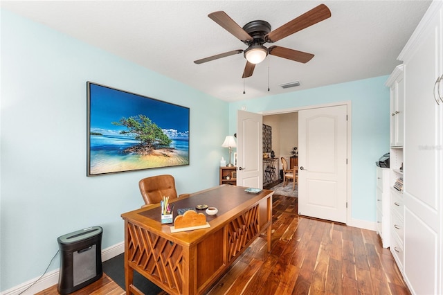 home office with ceiling fan and dark hardwood / wood-style flooring